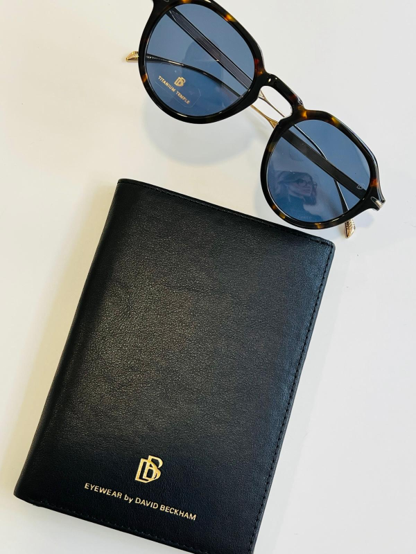 Scatole di lenti a contatto impilate sugli scaffali di un negozio. La maggior parte delle scatole sono blu e marroni.