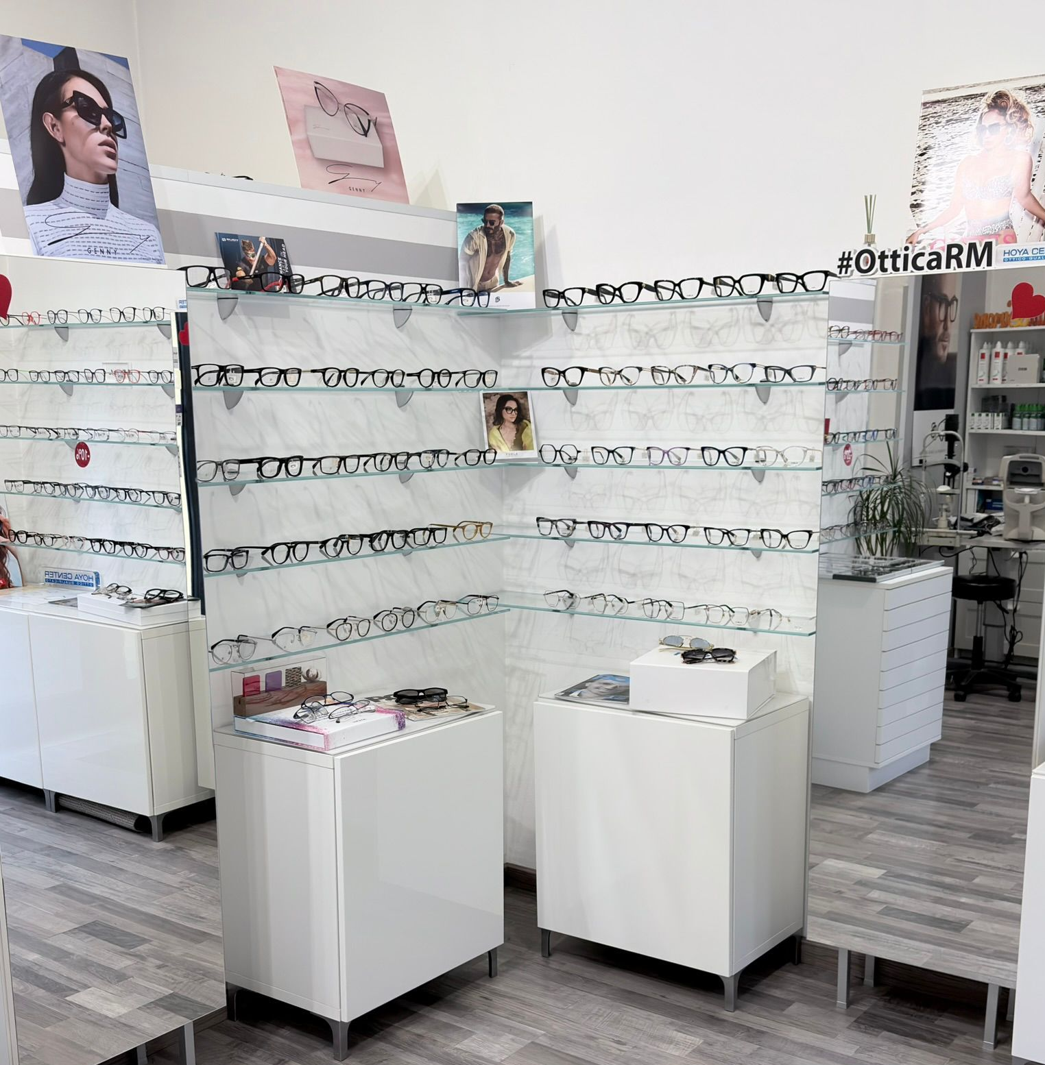 Occhiali da sole esposti su una rastrelliera metallica contro un muro di mattoni. Sono visibili modelli e colori assortiti.