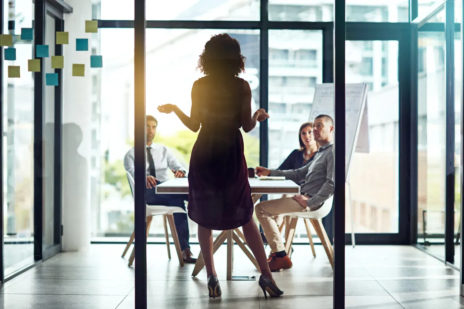 A woman is giving a presentation to a group of people in a conference room.