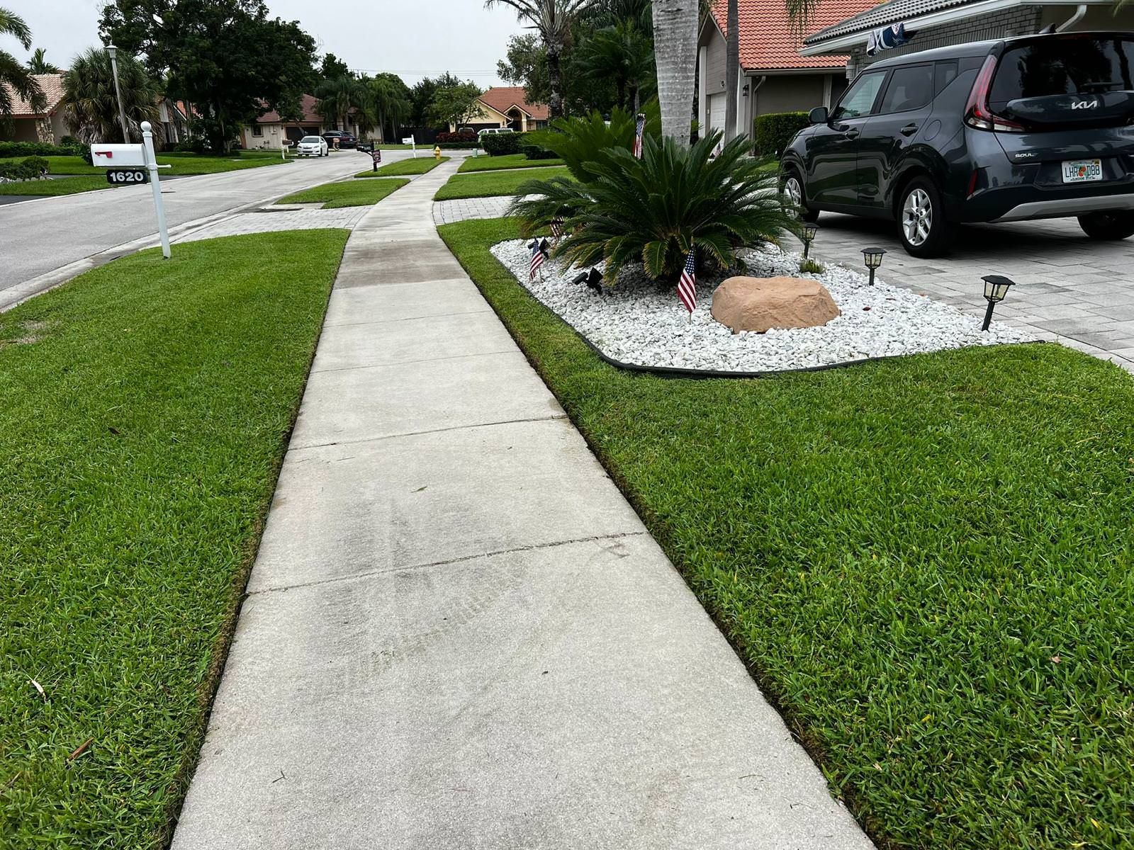 green garden along sidewalk.