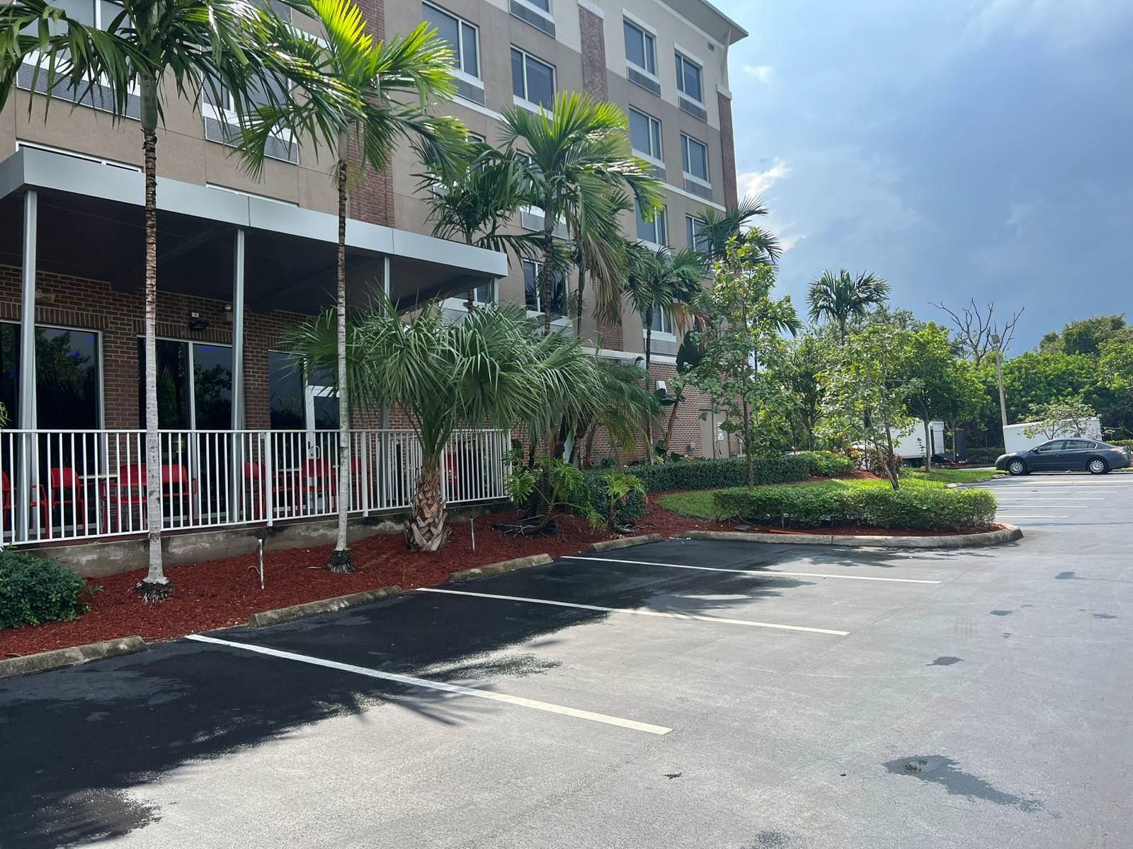 A large building with a parking lot surrounded with trees