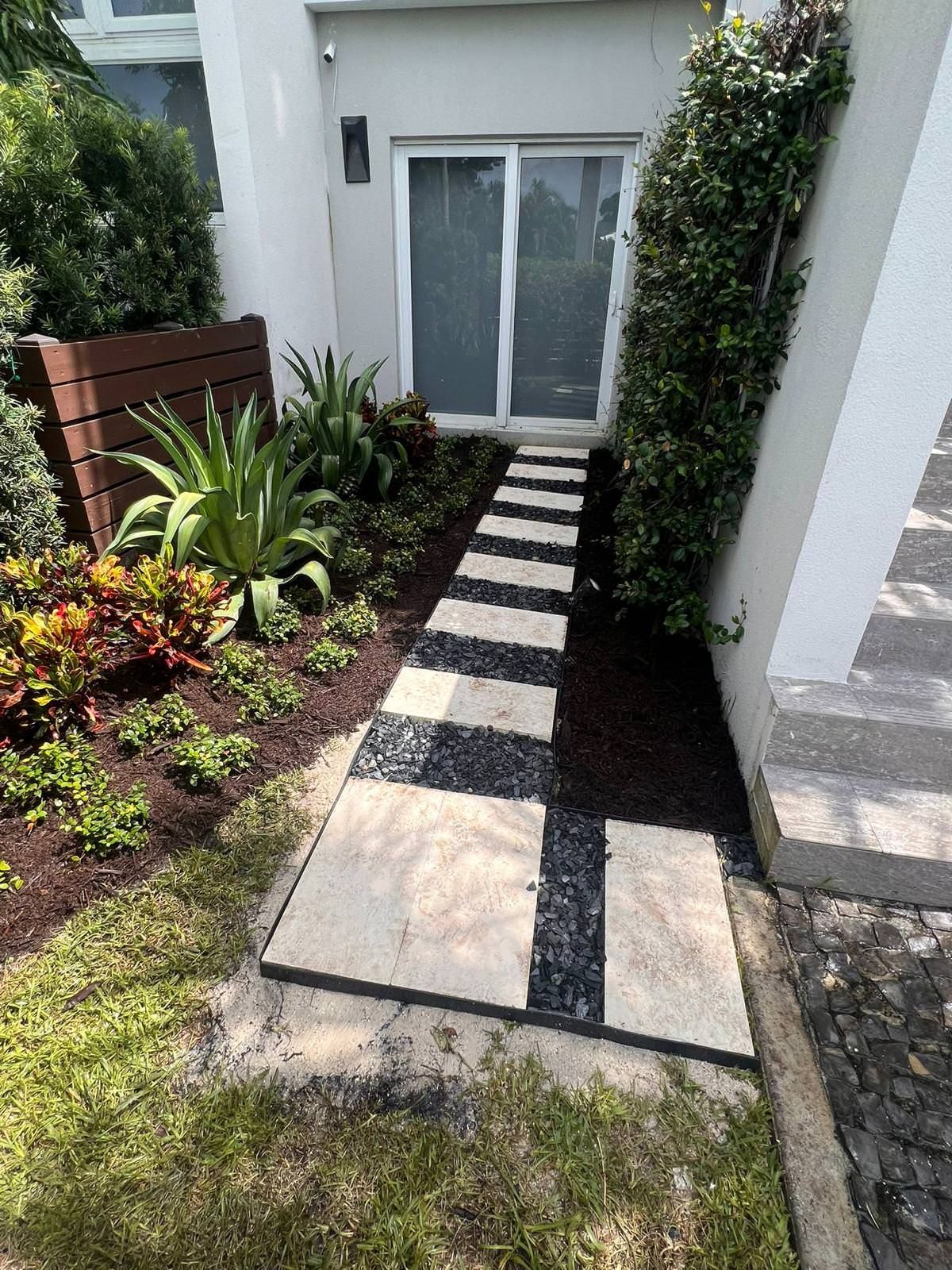 stone walkway leading to door and surrounded by green garden