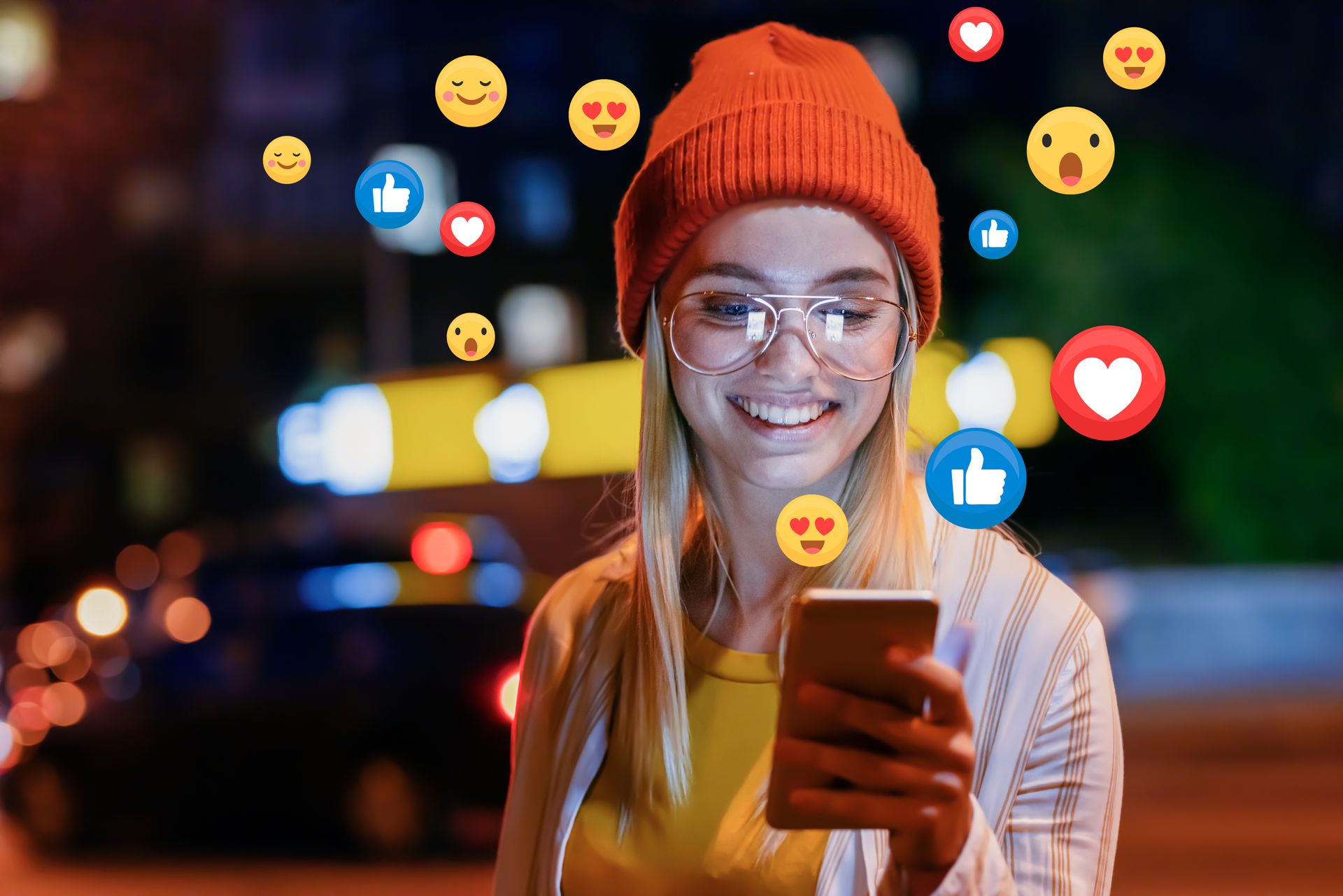 A woman wearing glasses and a beanie is using a cell phone.