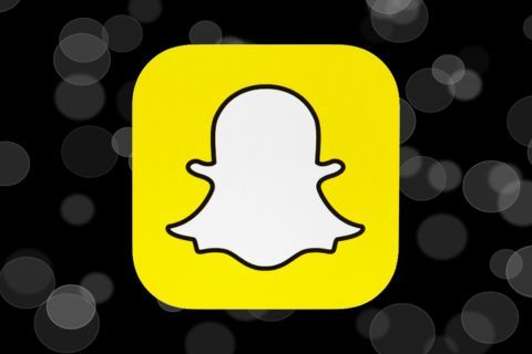 A snapchat icon on a black background with bubbles.