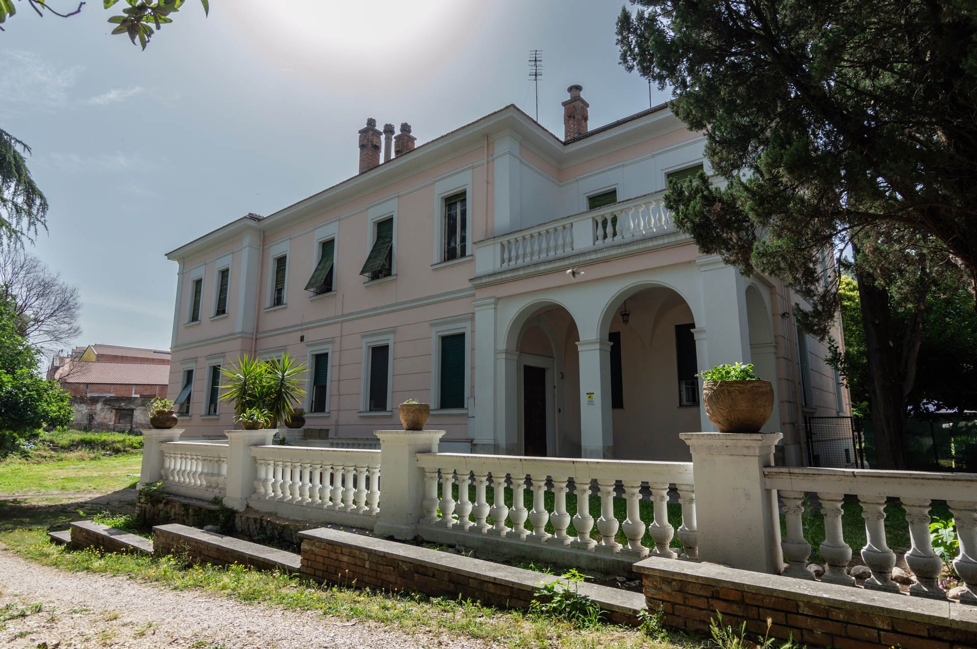 Una grande casa bianca con una staccionata bianca davanti