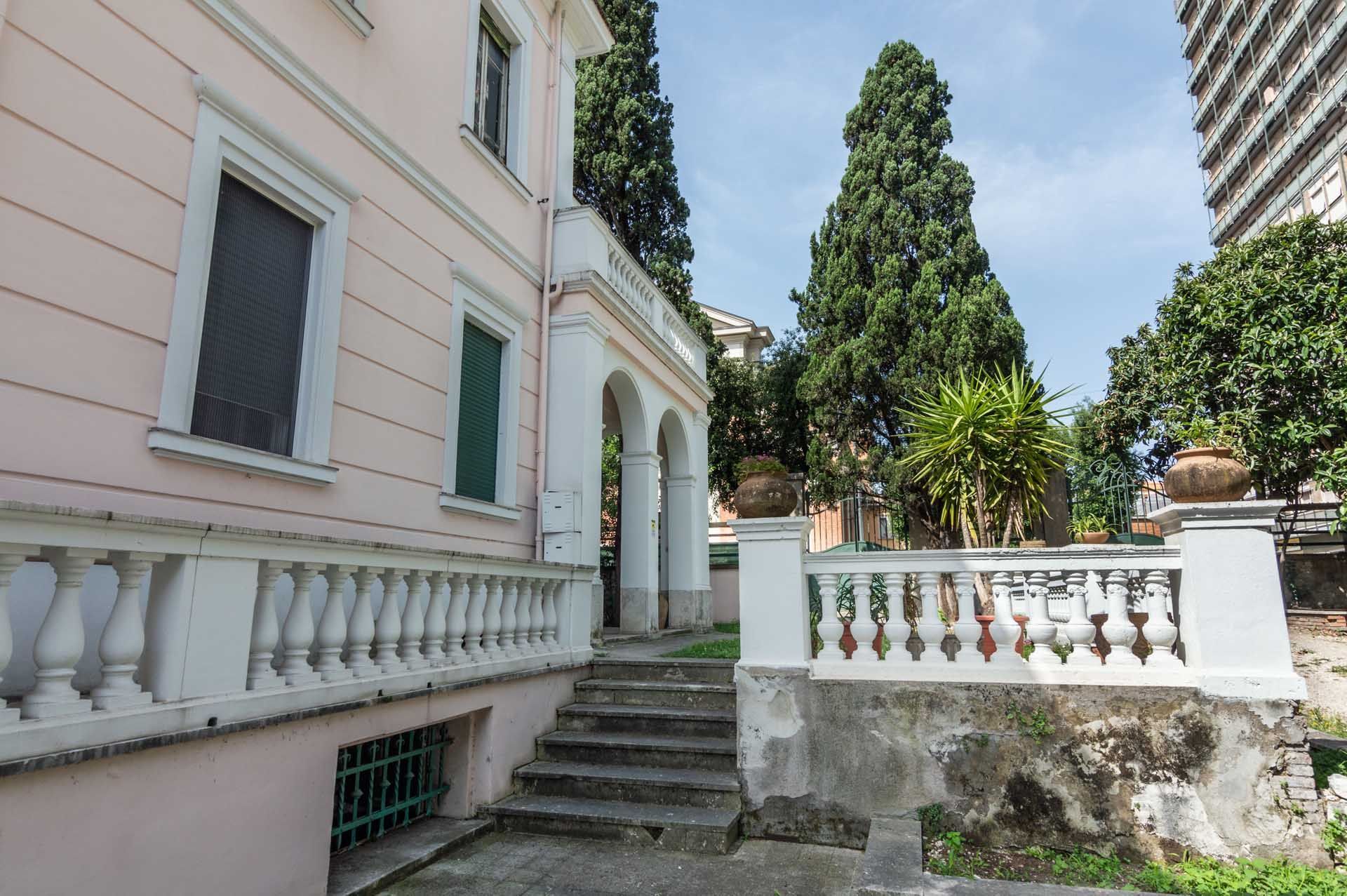 Un grande edificio rosa con scale che portano ad esso