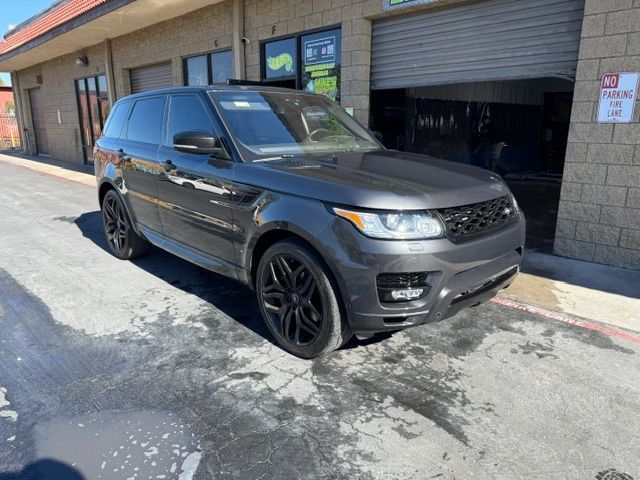 Dark gray Range Rover SUV parked outside a business with black wheels and tinted windows.