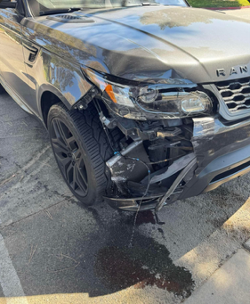 Damaged gray Range Rover SUV; front end collision with significant damage to the driver's side.