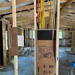 Technician Plugging Wires Into A Box On A Wall - Palatka, FL - Davis Electric Services LLC