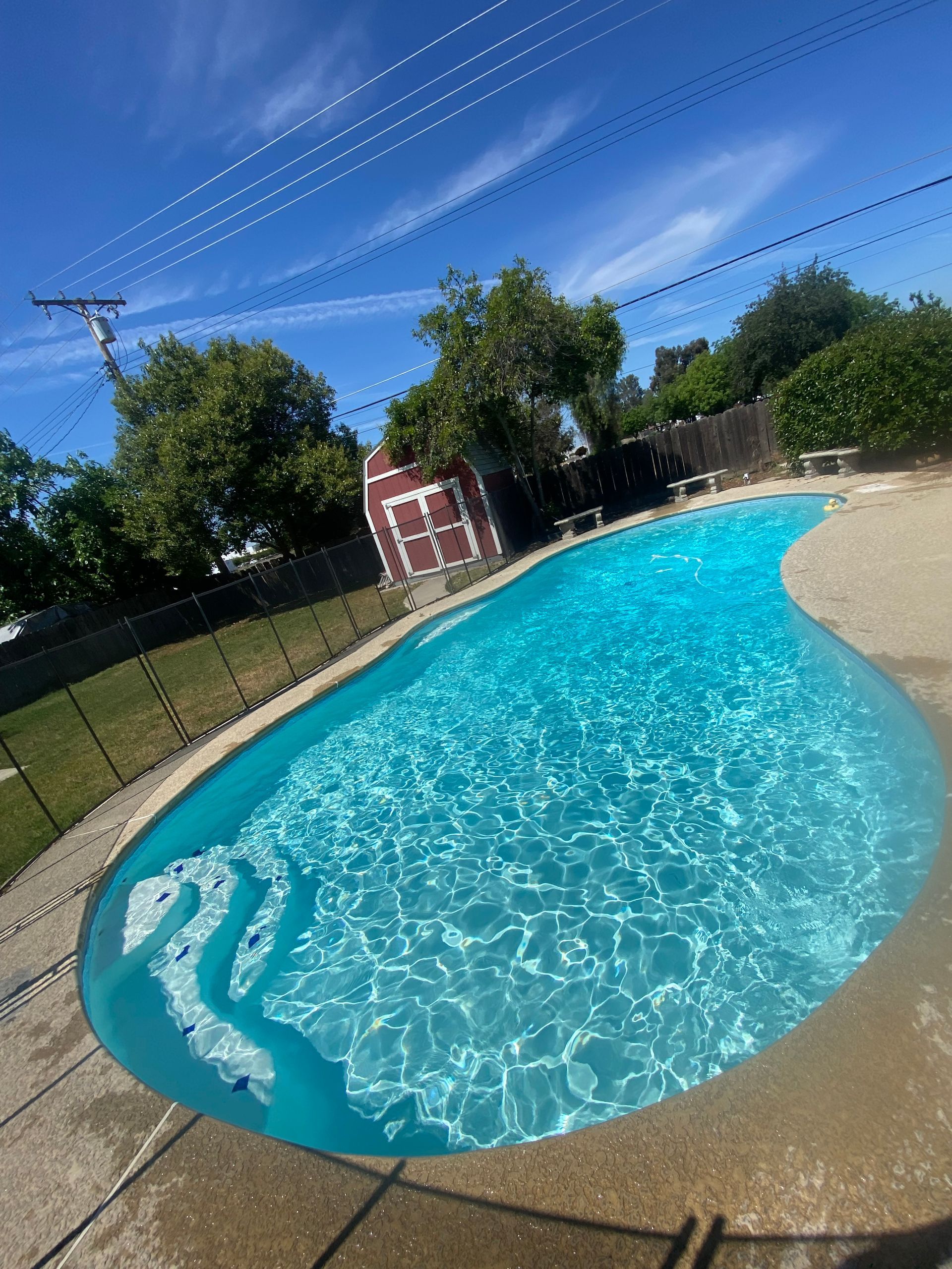 A large swimming pool with a red barn in the background