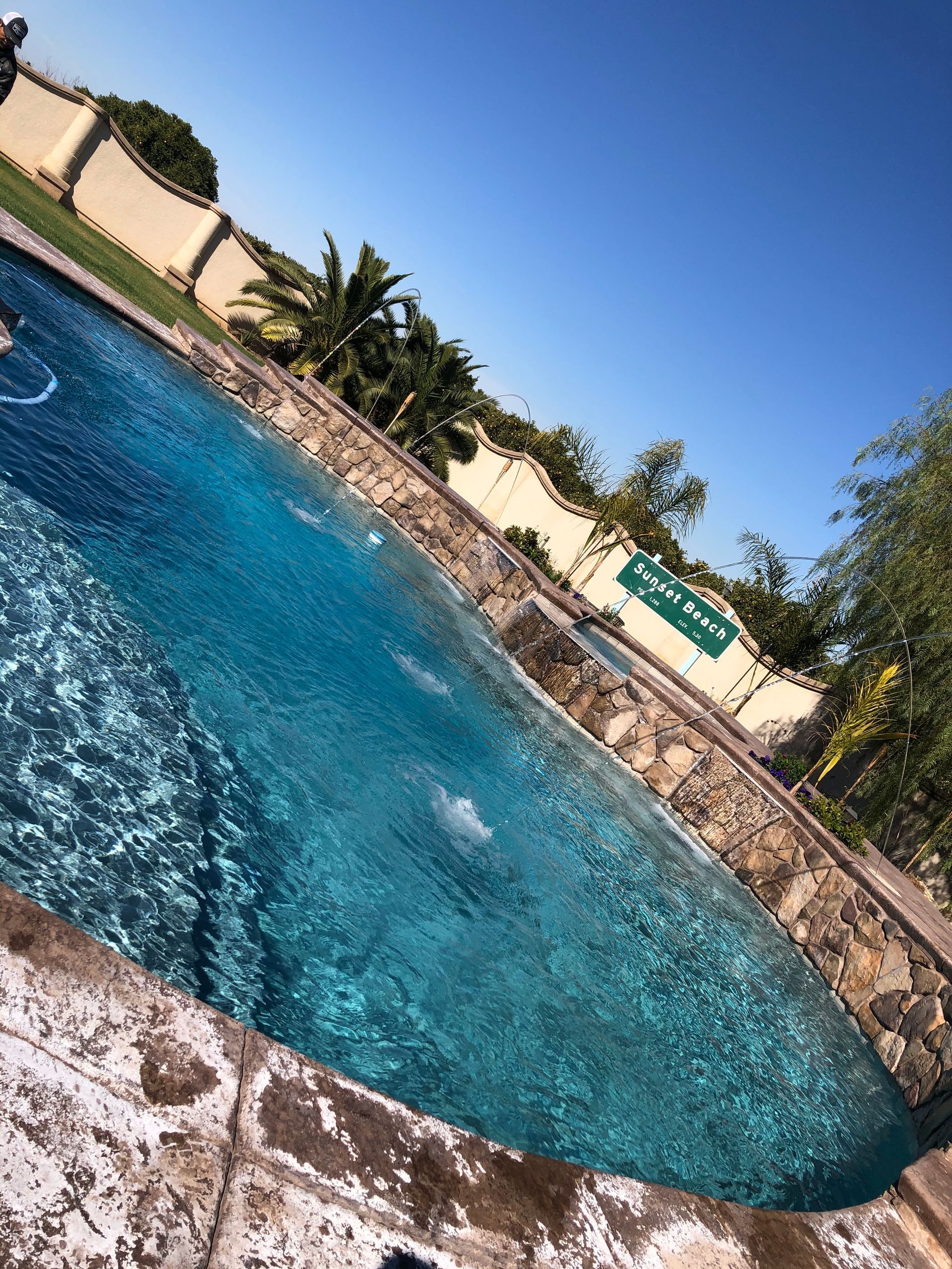 A large swimming pool with a fence in the background