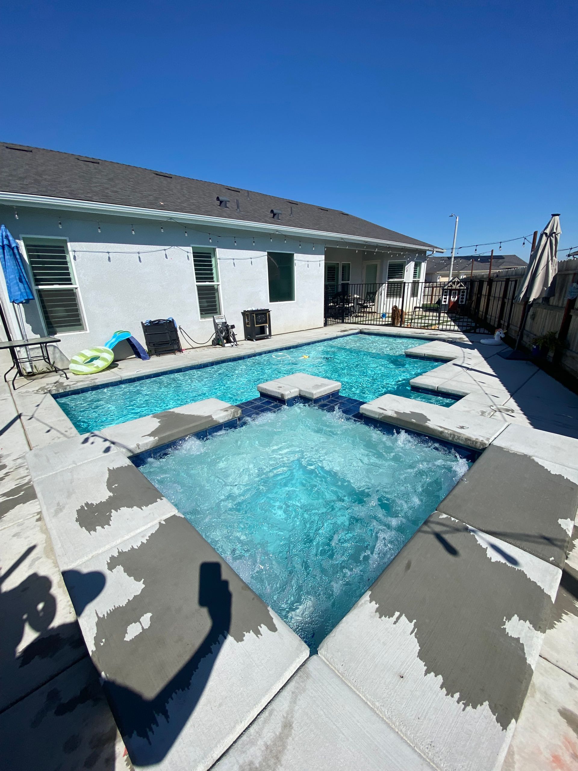A large swimming pool with a hot tub in the middle of it