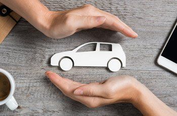 Hands Covering a Cutout Car — Miami, FL — American Quality Assurance Group