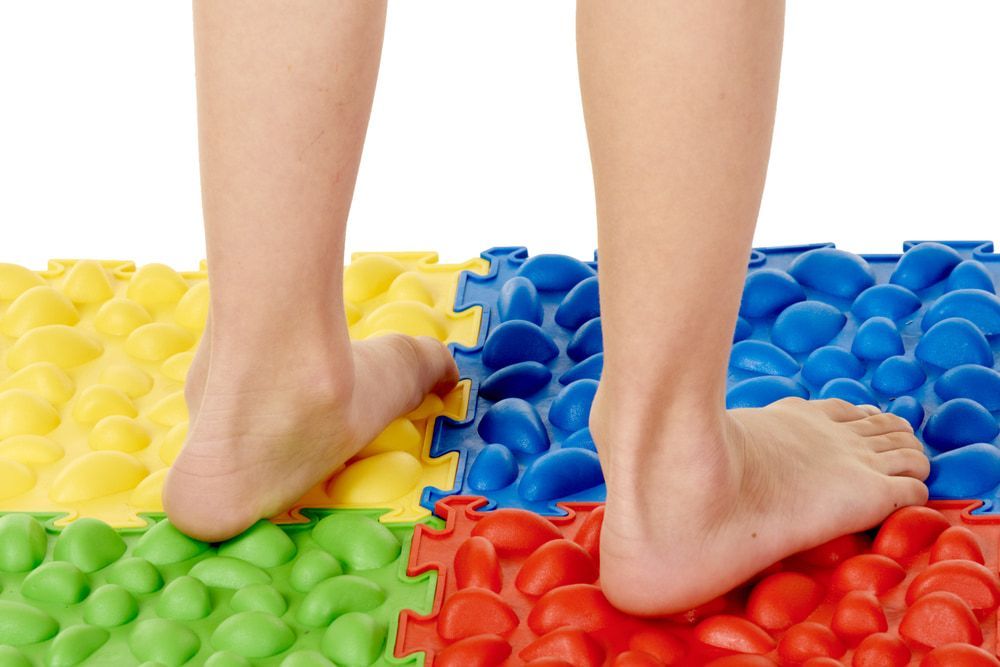 A Person's Feet Are Standing on A Colorful Mat — Swan Podiatry and Orthotics in Coconut Grove, NT