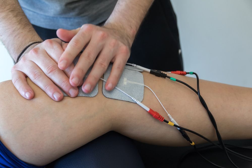 A Person Is Getting Electrodes on Their Knee — Swan Podiatry and Orthotics in Coconut Grove, NT