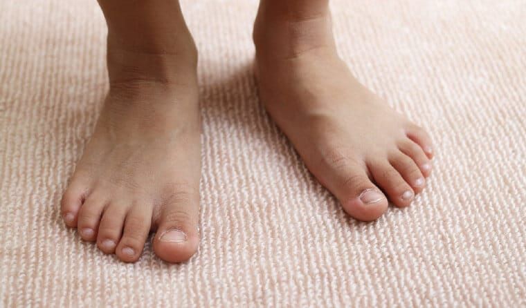 A Child's Bare Feet Are Standing on A Carpet — Swan Podiatry and Orthotics in Coconut Grove, NT