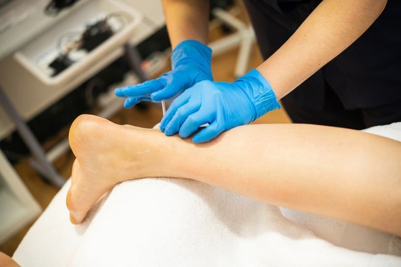 A Person Wearing Blue Gloves Is Getting a Massage — Swan Podiatry and Orthotics in Coconut Grove, NT