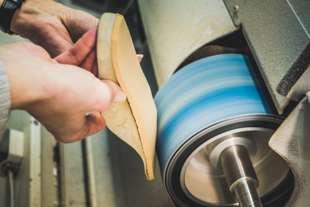 A Person Is Polishing a Shoe with A Machine — Swan Podiatry and Orthotics in Coconut Grove, NT