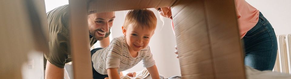 Mom, Dad, and Baby playing with cardboard boxes | Four Season Sales Property Management