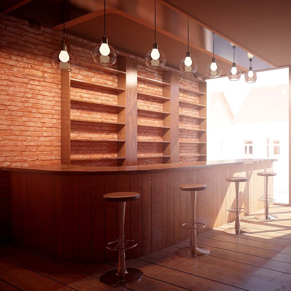 A bar with stools and a brick wall.