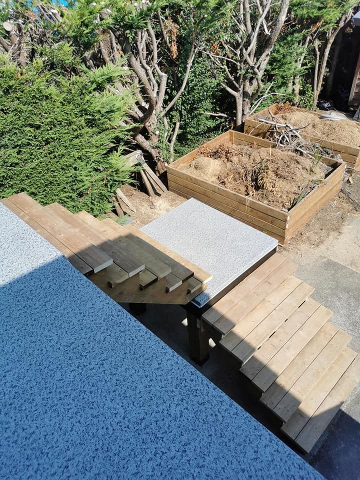 A wooden staircase is being built in a backyard.