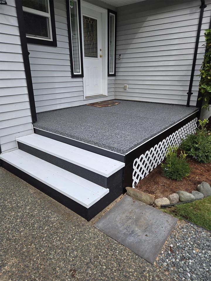 A porch with stairs leading up to the front door of a house.