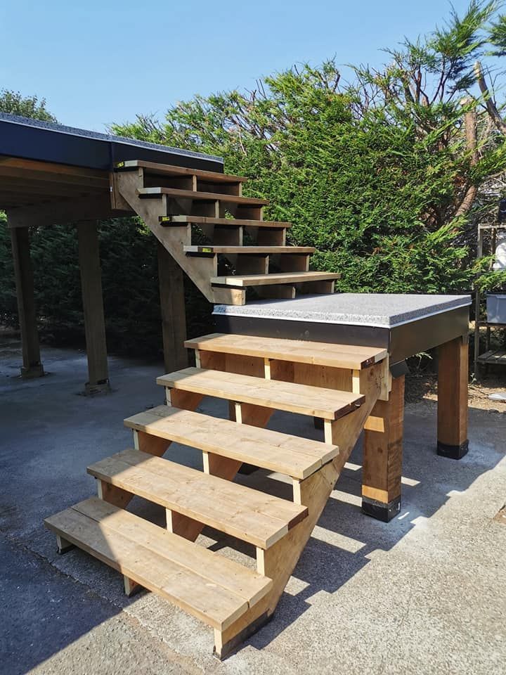 A set of wooden stairs leading up to a concrete platform.