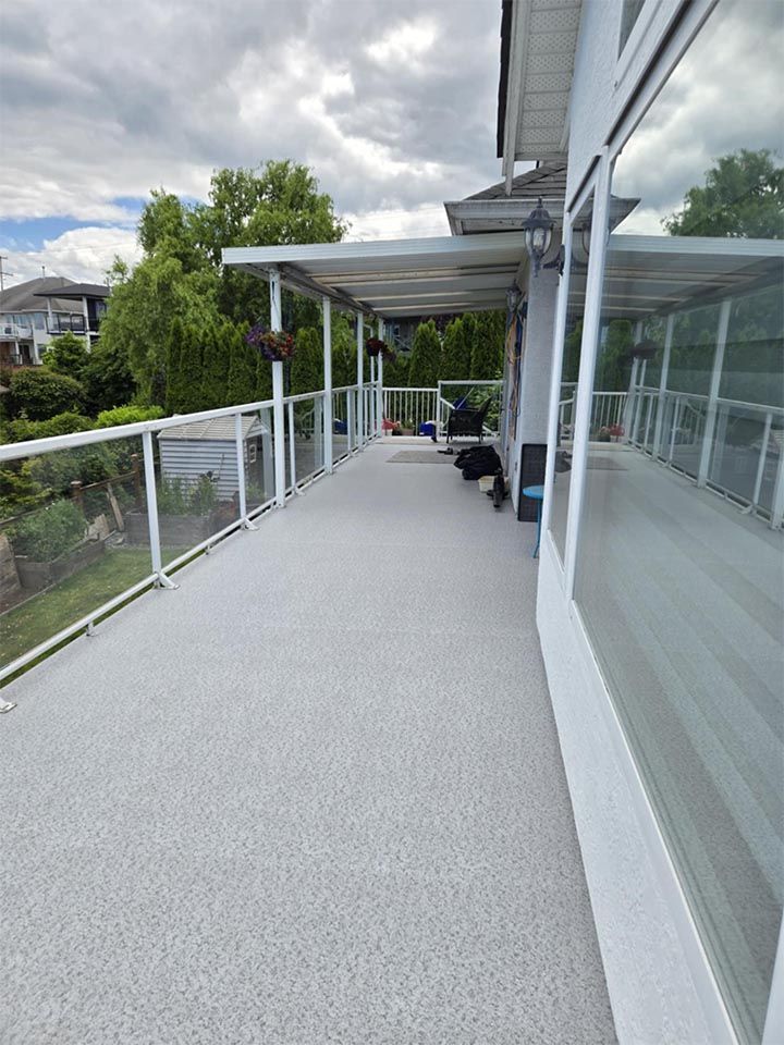A large white deck with a glass railing.