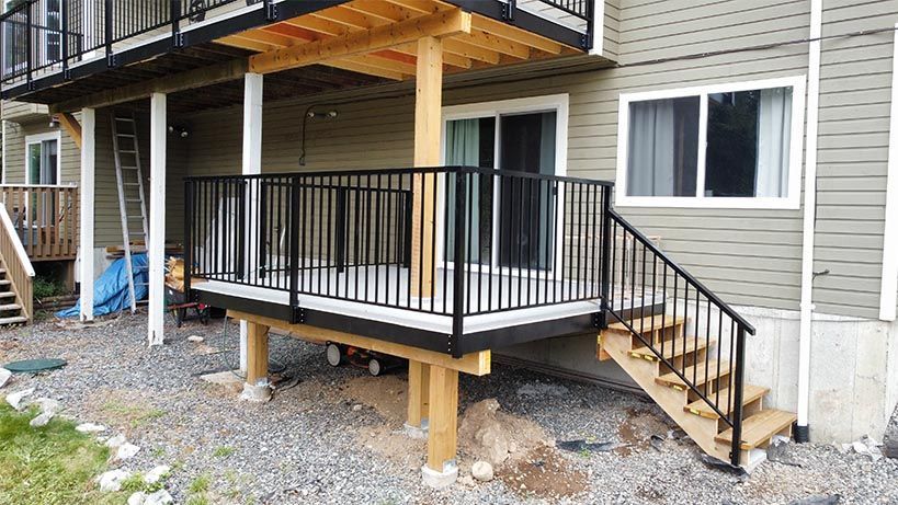 A deck with stairs leading up to it is being built in front of a house.
