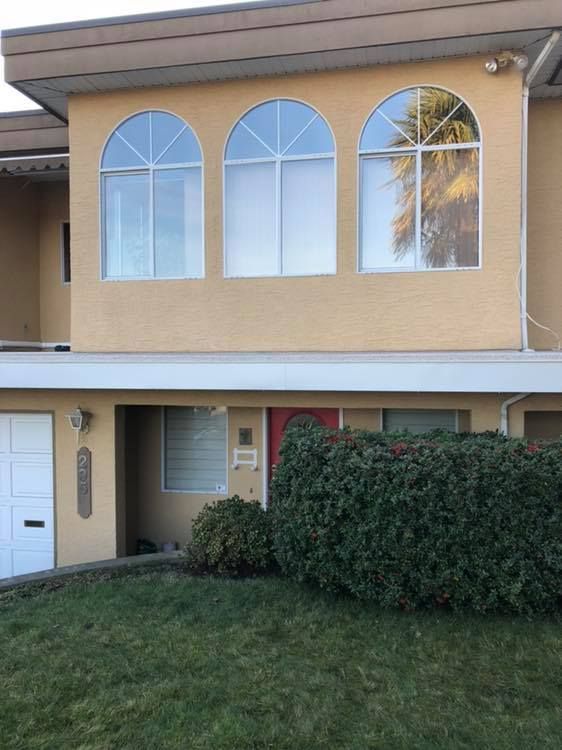 A house with three arched windows and a red door.