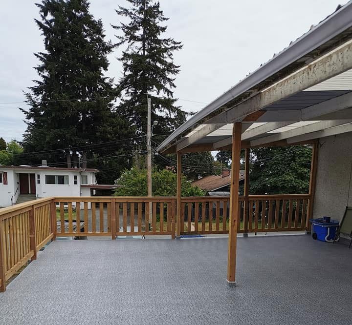A deck with a wooden railing and a clear roof.