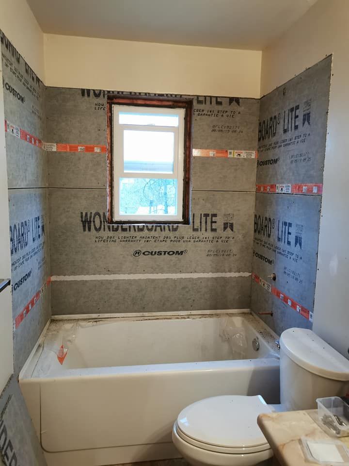 A bathroom with a tub a toilet and a window.