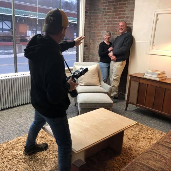 A man taking a picture of two people in a living room