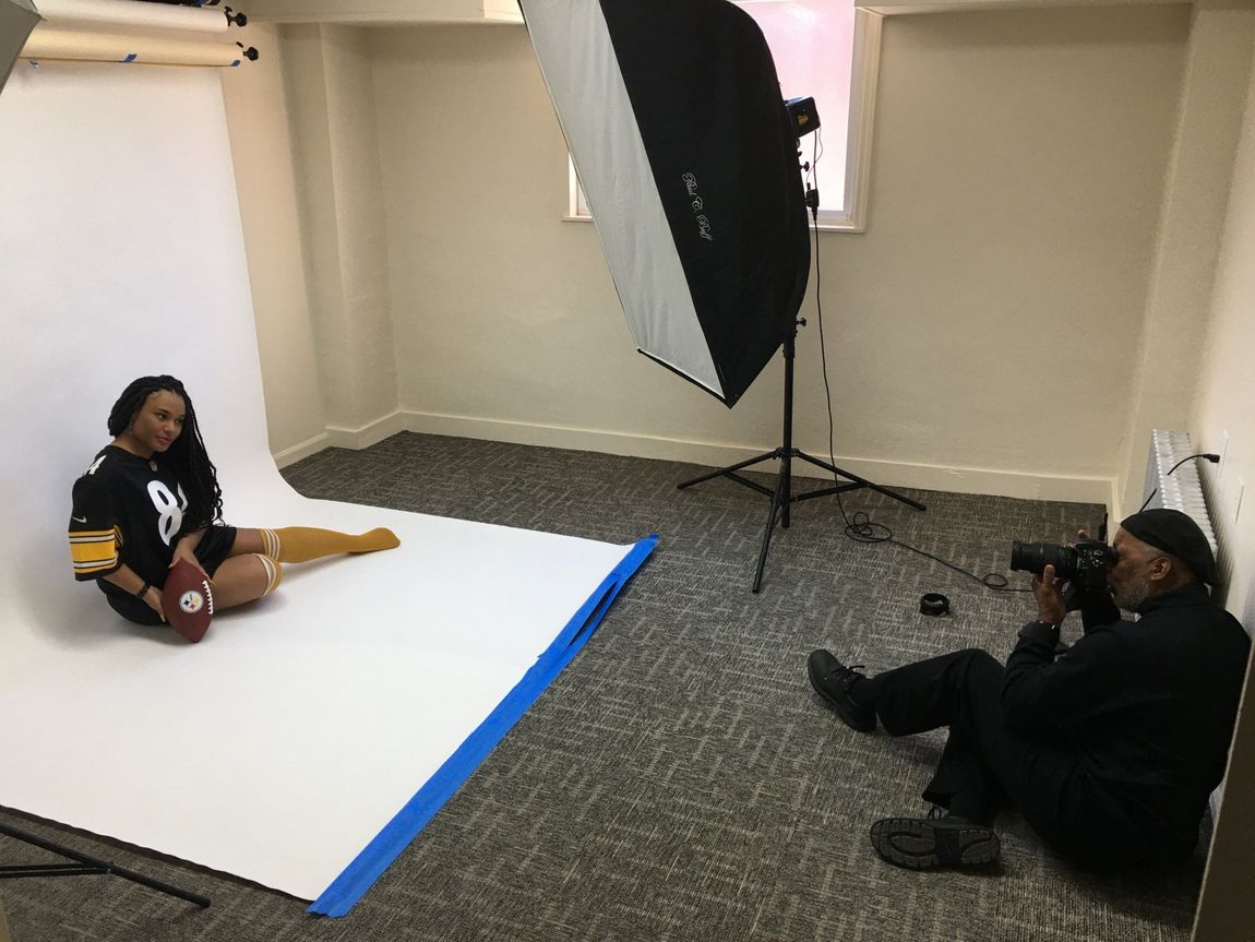 A man is taking a picture of a woman in a photo studio.
