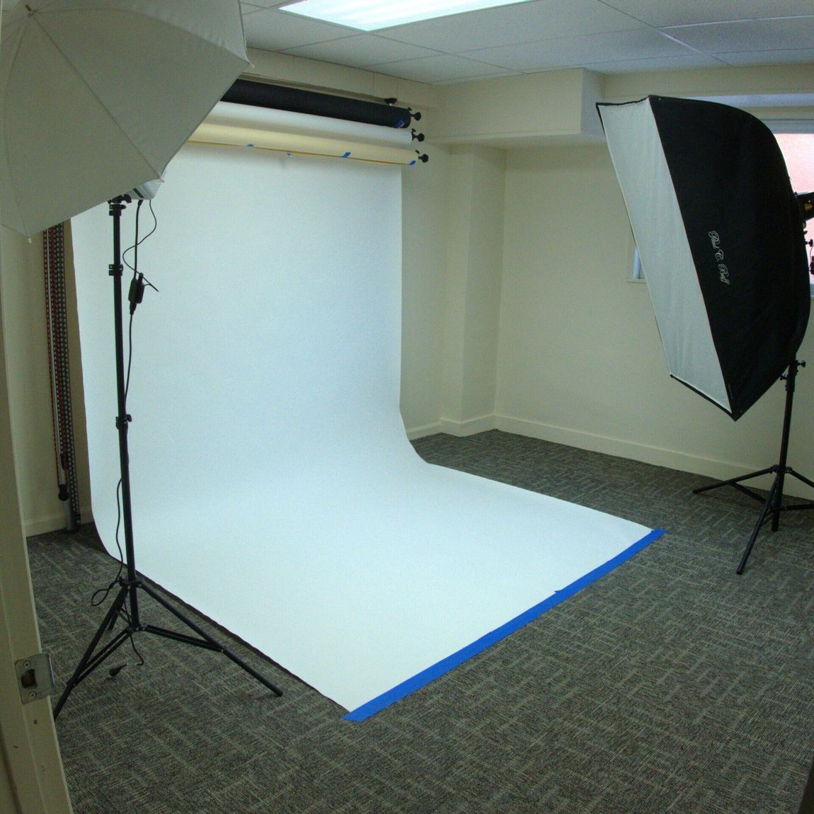 A photo studio with a large white sheet of paper on the floor