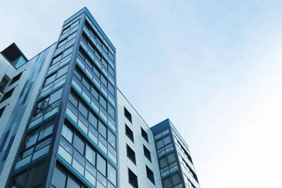 Looking up at a tall building with a blue sky in the background.