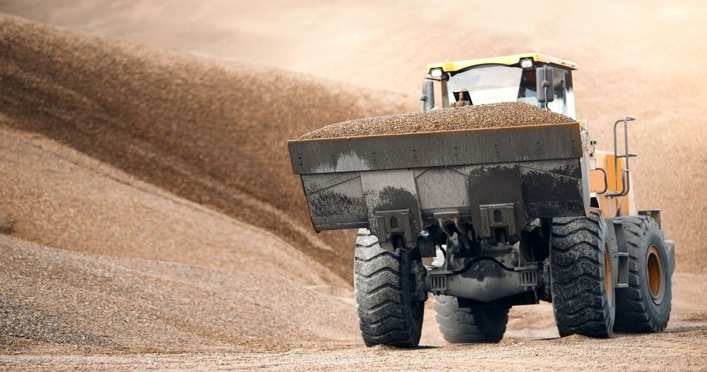 A dump truck is driving down a dirt road.