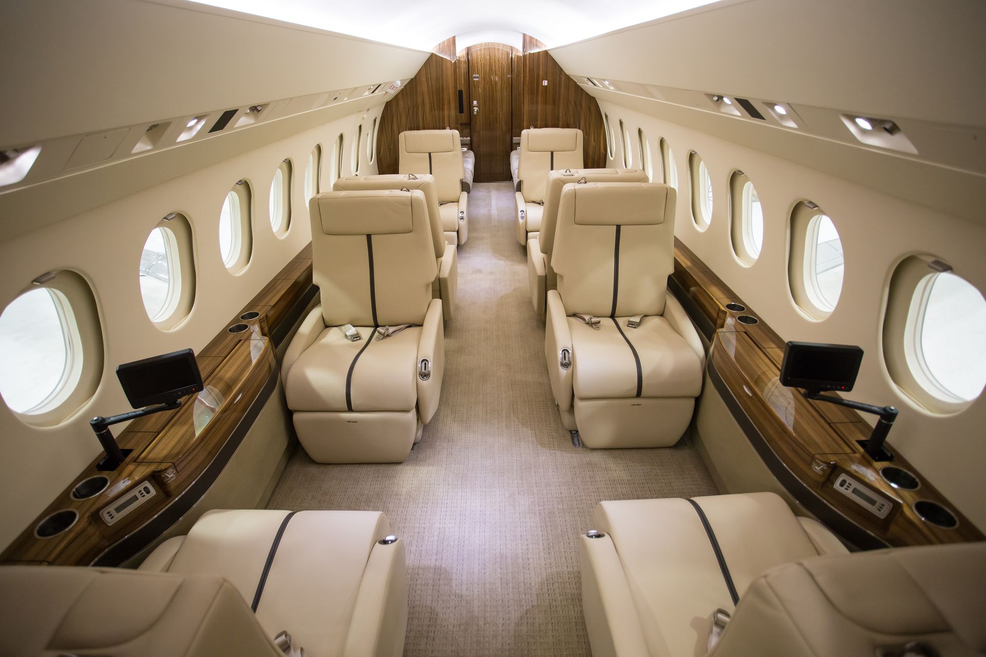 The inside of a private jet with lots of seats and windows