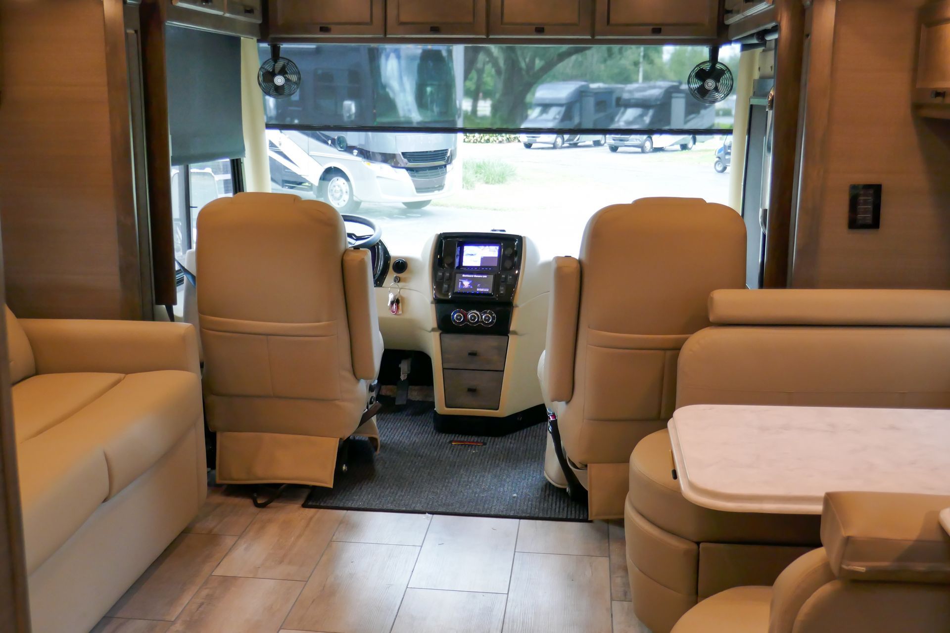 The inside of a rv with a couch , table and chairs.