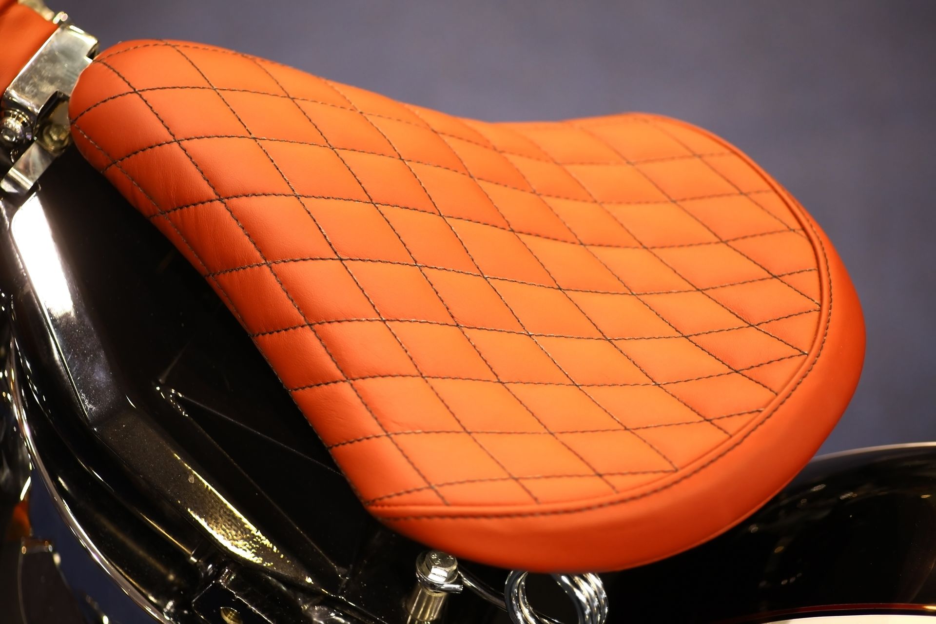 A close up of an orange seat on a motorcycle