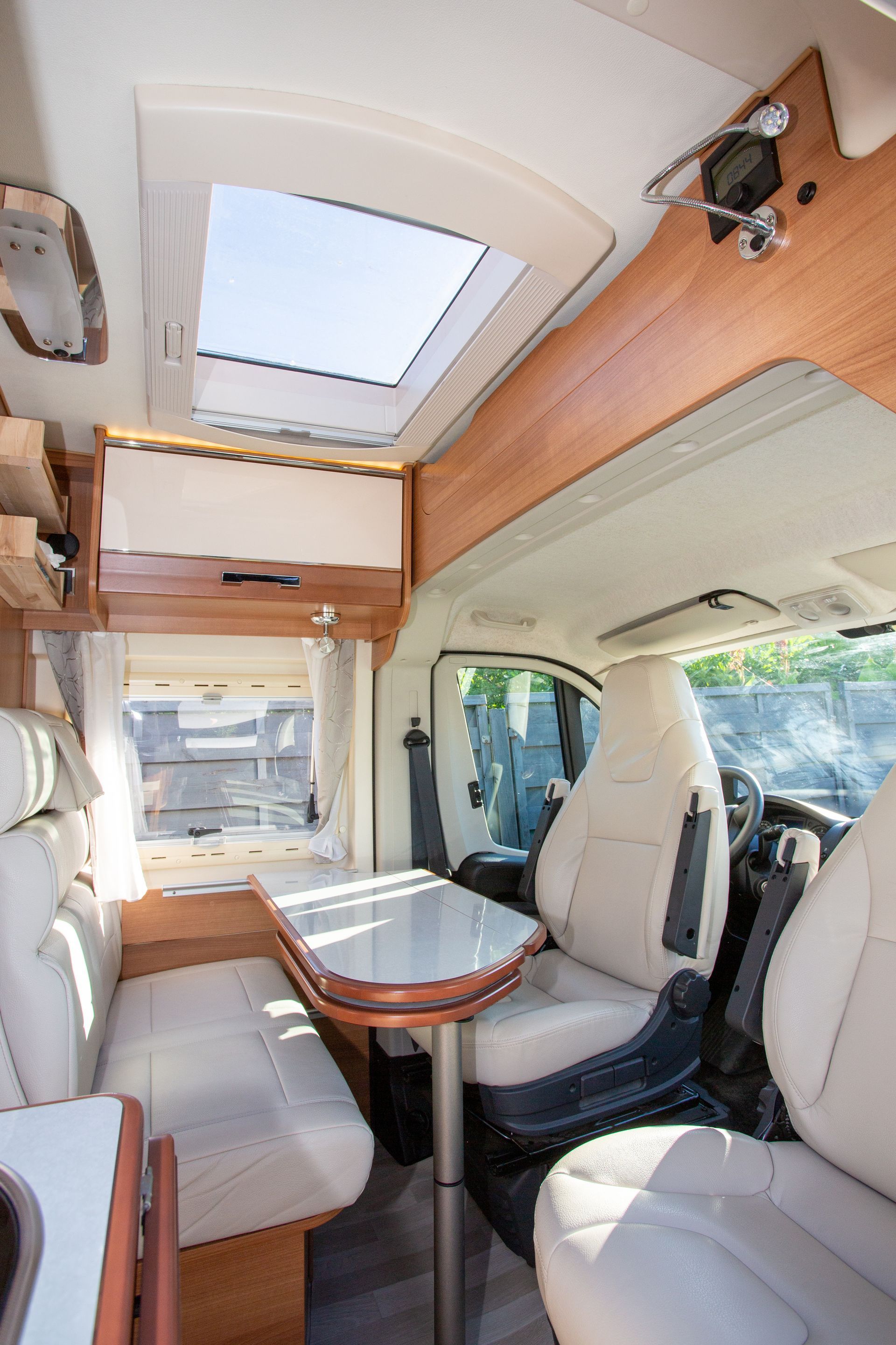 The inside of a camper van with a table and chairs.