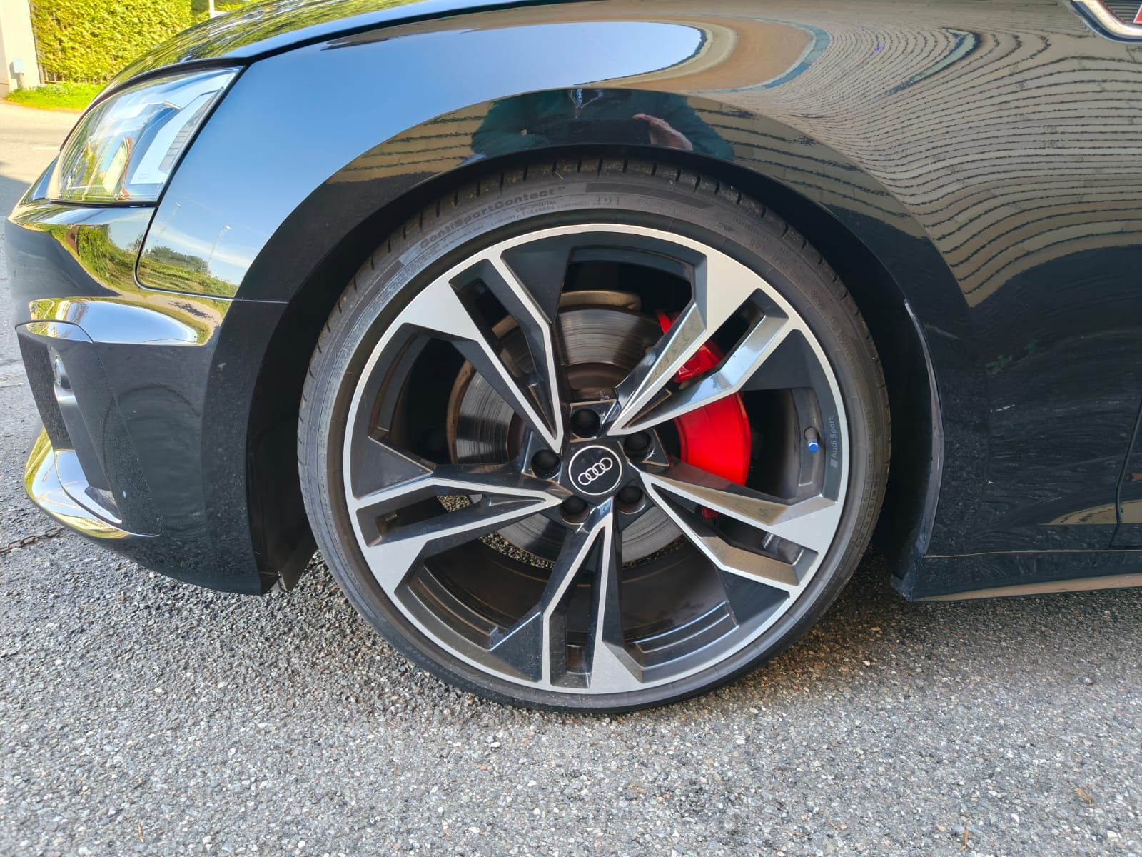 Cerchio nero per auto con pinza freno rossa.