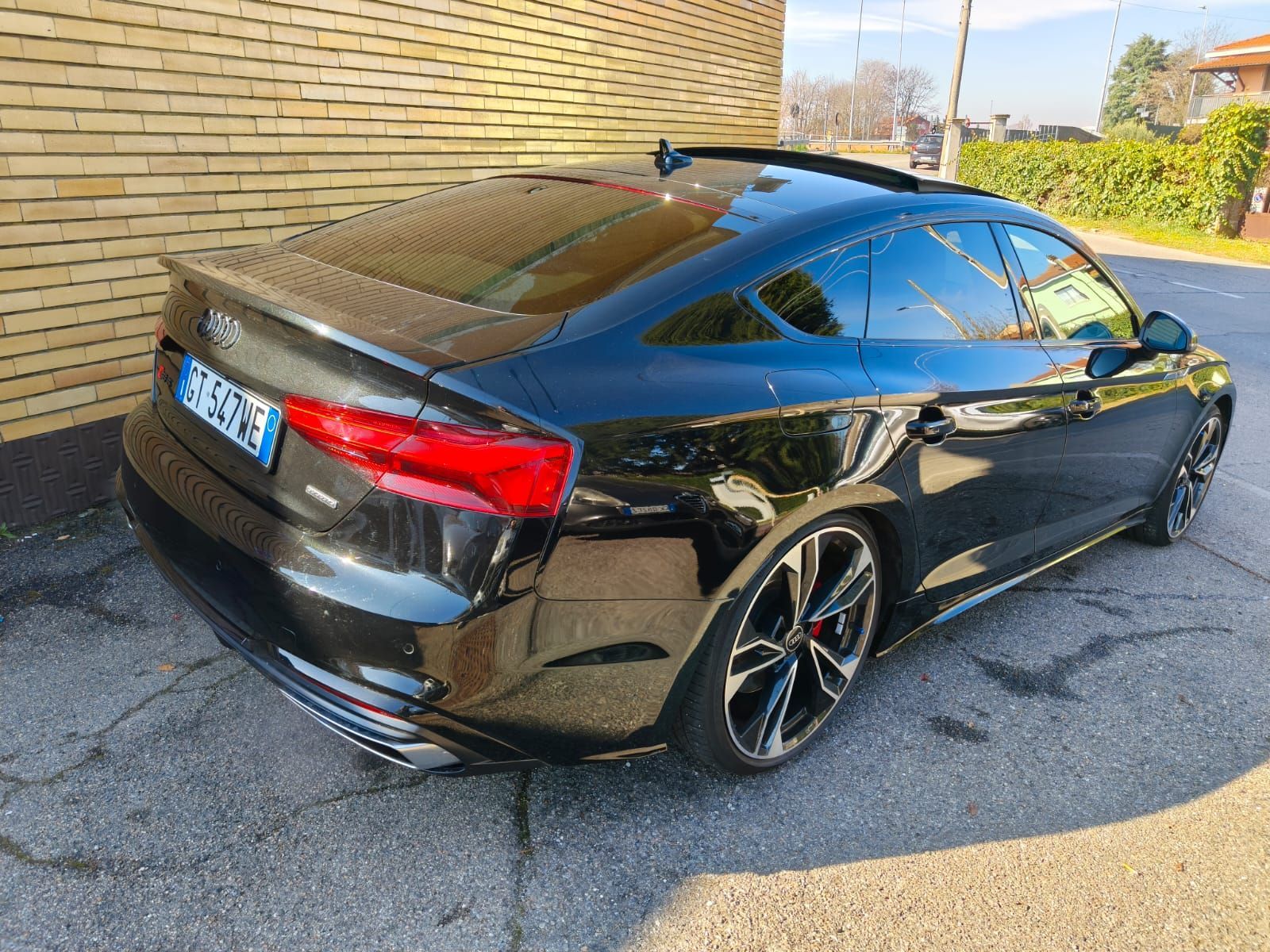 Audi coupé nera parcheggiata in strada; vetri lucidi e oscurati, tettuccio apribile, ruote grandi.