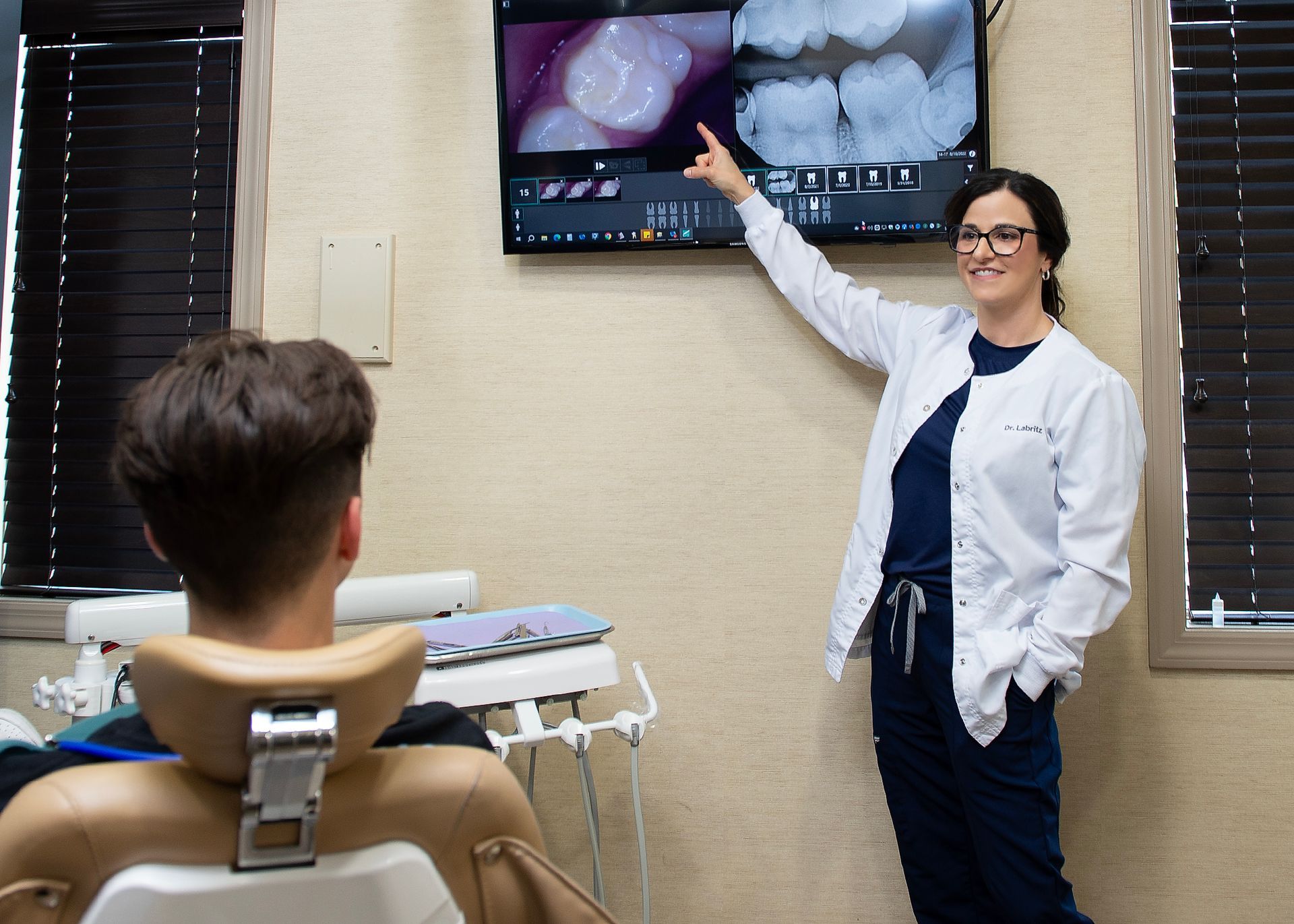 A dentist is giving a presentation to a patient in a dental office.