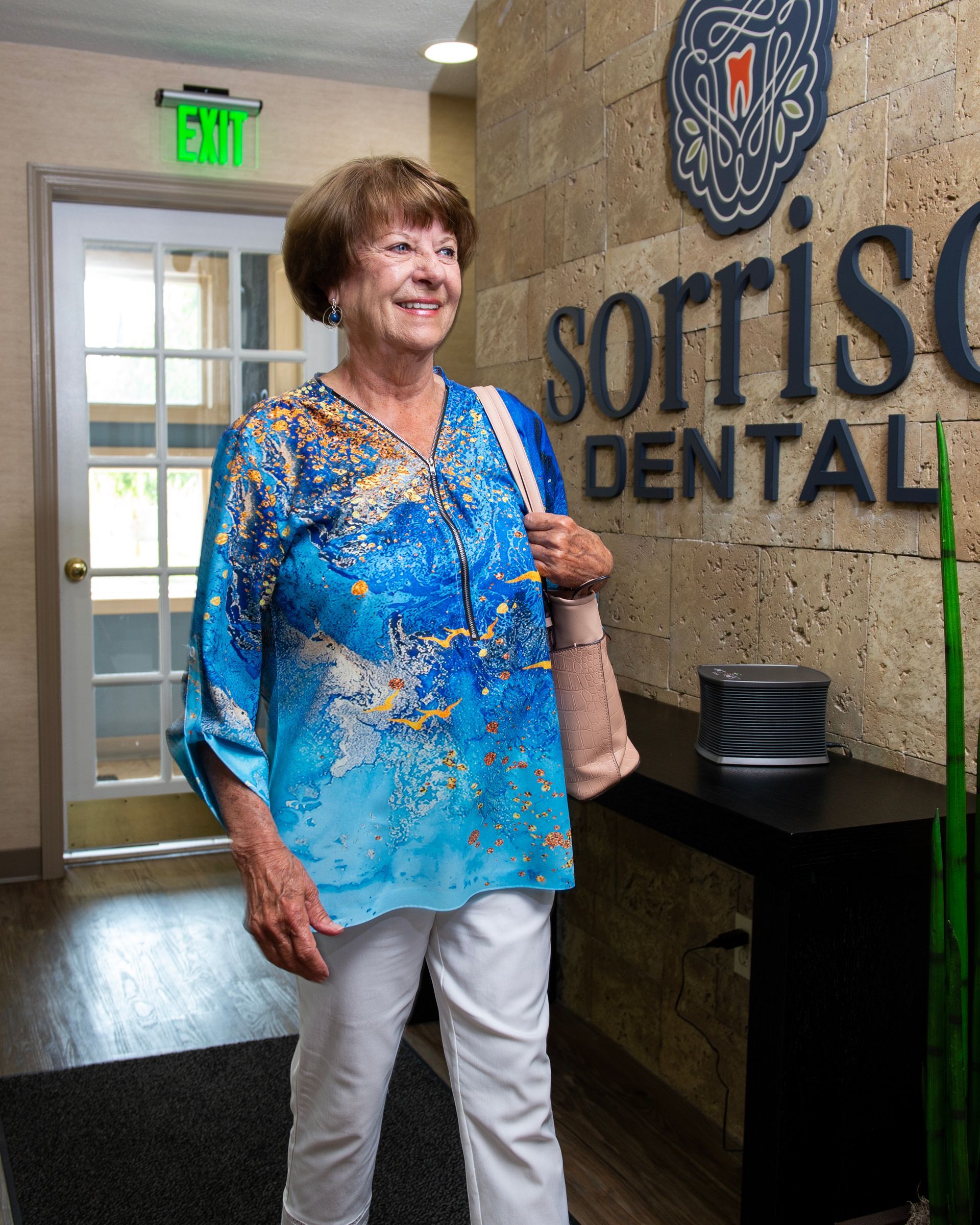 A woman is standing in front of a sign for sorris dental