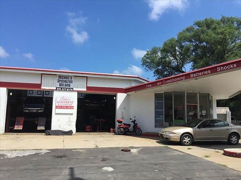 A car is parked in front of a tire shop.