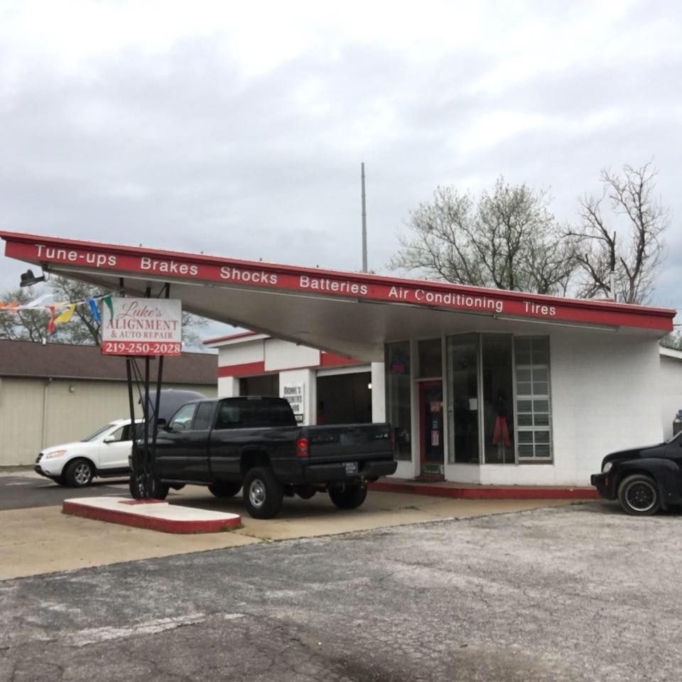 A truck is parked in front of a building that says tune ups brakes shocks batteries air conditioning tires