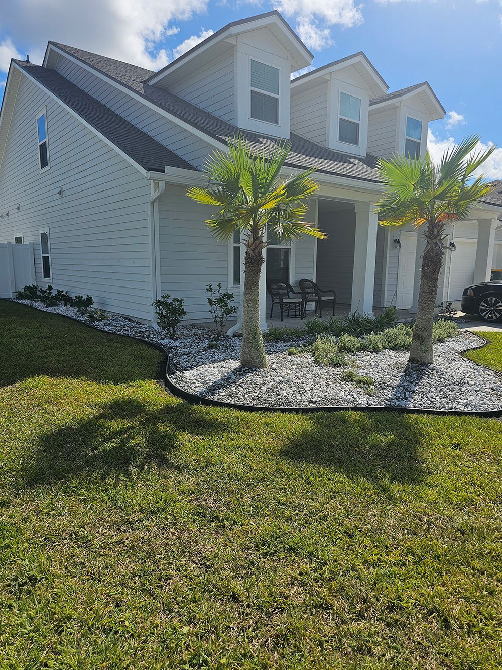 A white house with a palm tree in front of it.