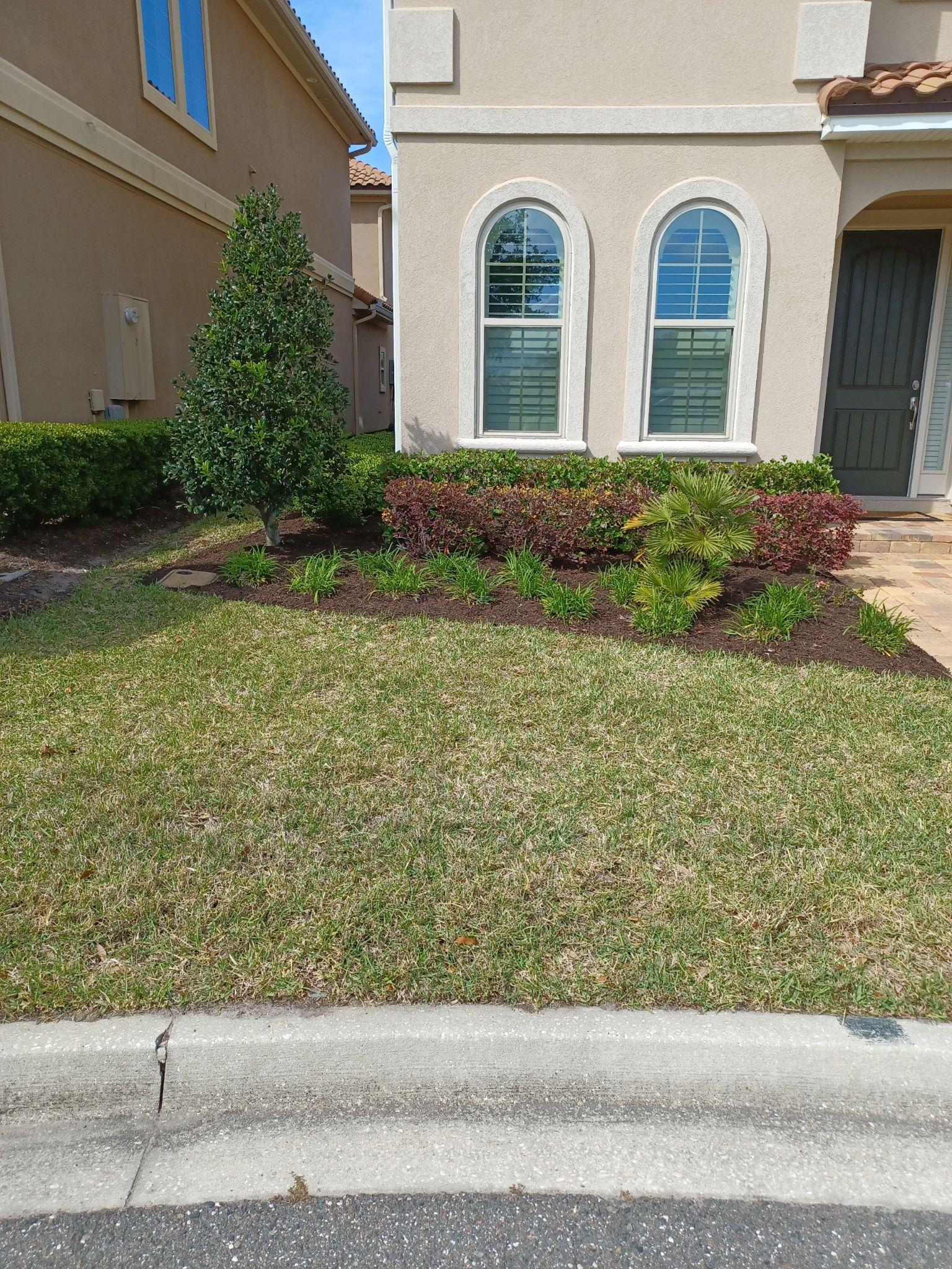 A house with a lush green lawn in front of it.