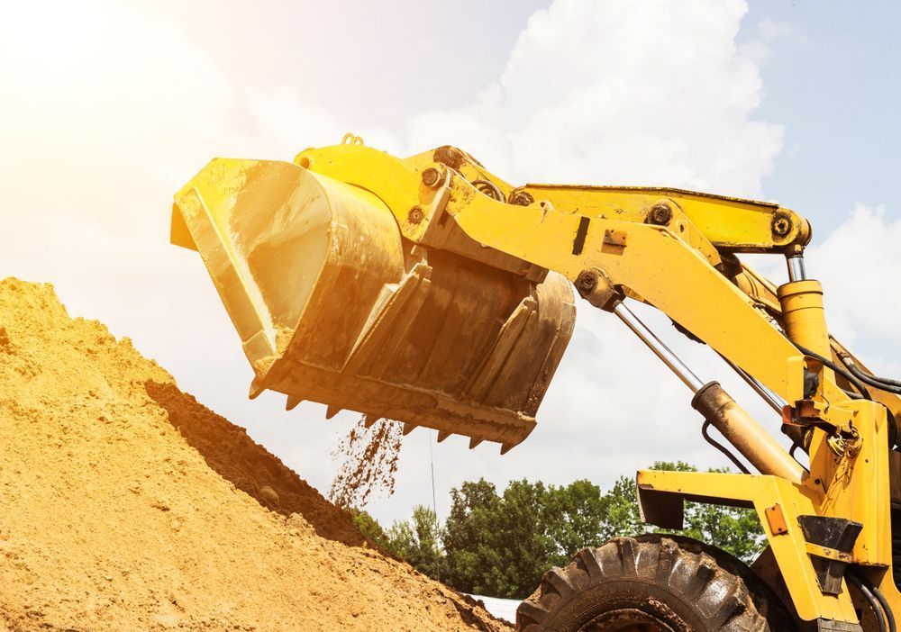 A Bulldozer Is Loading Dirt Into a Pile on A Construction Site — Lifestyle Demolition In Evans Head, NSW